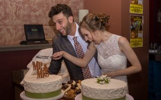 a bride and groom are cutting wedding cakes