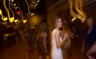 a bride is smiling while dancing with others